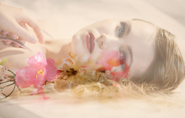 Double exposure of beautiful woman portrait lying and soft flowers - Φωτογραφία, εικόνα