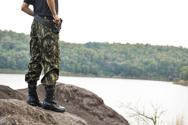 Soldier stand on the rock in nature background - 写真・画像