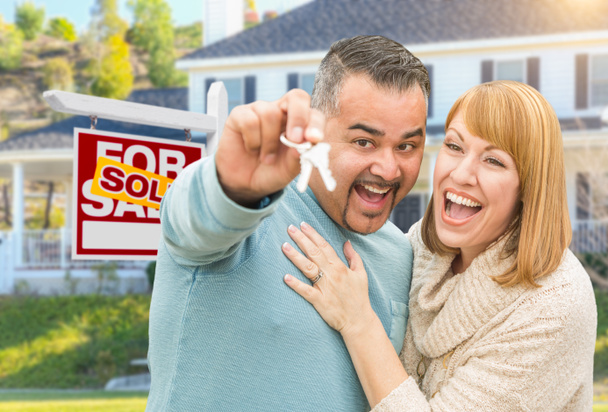 Mixed Race Couple With Keys in front of Real Estate Sign and New
 - Фото, изображение