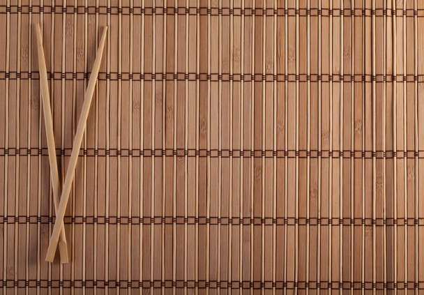 Dos palillos sobre fondo de sushi
 - Foto, Imagen