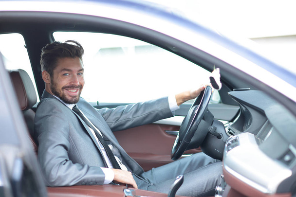 Portrait of an handsome smiling business man driving his car - Foto, Imagem