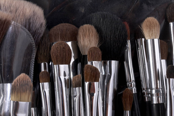 Nahaufnahme vieler verschiedener professioneller natürlicher weicher Make-up-Pinsel für Lidschattenpuder und Gesichtscreme für Visagisten in den Farben schwarz braun und weiß - Foto, Bild