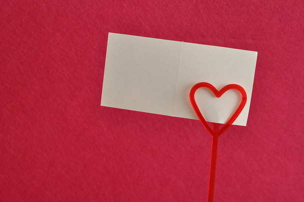 Día de San Valentín. Un sostenedor de nota con un corazón rojo
 - Foto, imagen