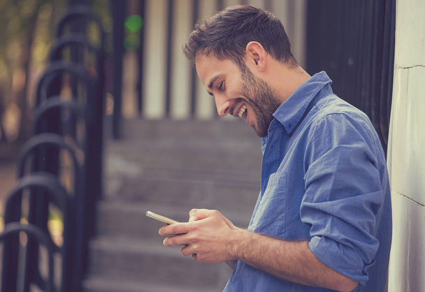 Man texting on mobile phone outdoors  - Photo, image