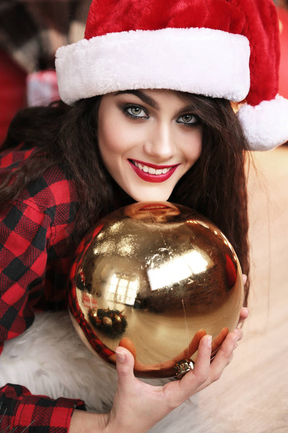 charming woman with dark hair posing near Christmas tree - Fotó, kép