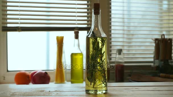 Olívaolaj üveg a konyhaasztalon. Rozmaringos extra szűz olívaolaj - Felvétel, videó
