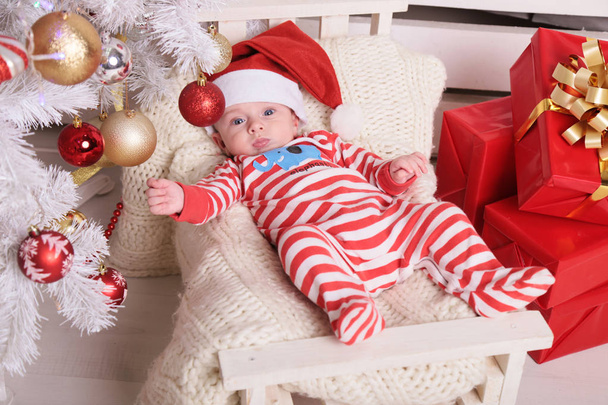 cute little Santa baby at cozy home with New Year decoration   - Fotó, kép