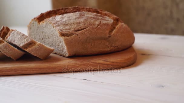Нарізати хліб на обробній дошці. Домашній шматочок хліба. Запечений продукт
 - Кадри, відео