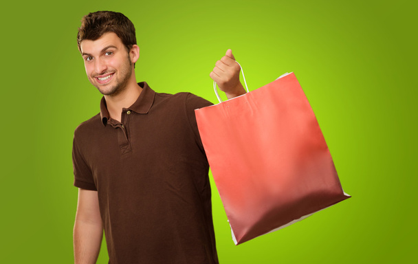 Retrato de un joven sosteniendo la bolsa de compras
 - Foto, imagen