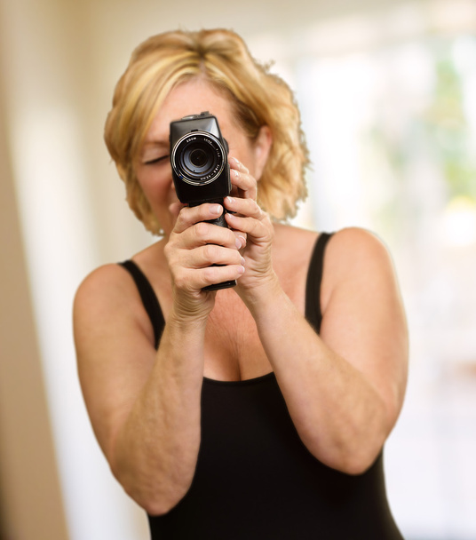 Kypsä nainen katselee kameran läpi
 - Valokuva, kuva