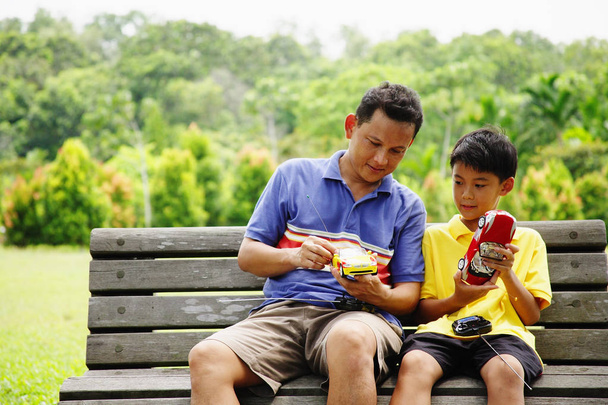 Father and son on bench - 写真・画像