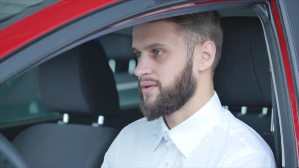 νεαρός άνδρας που κάθονται στο αυτοκίνητο που κατέχει τα κλειδιά του αυτοκινήτου - Πλάνα, βίντεο