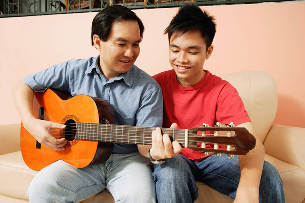 Père et fils jouent à la guitare
 - Photo, image