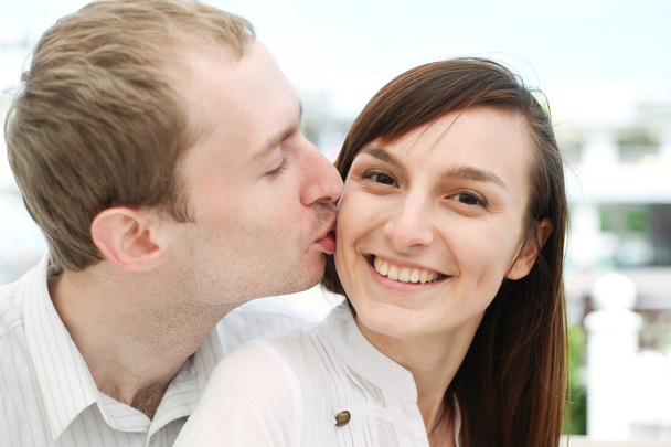 Portrait of young man kissing his girlfriend - Photo, Image
