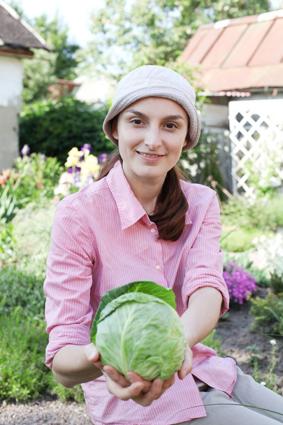 Happy girl with vegetables harvest in garden - Foto, afbeelding