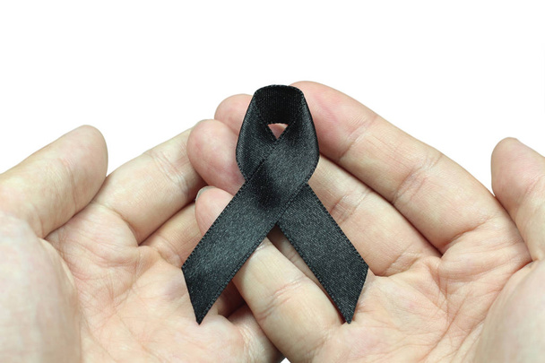 Hand holding black ribbon for mourning concept on white background  - Valokuva, kuva