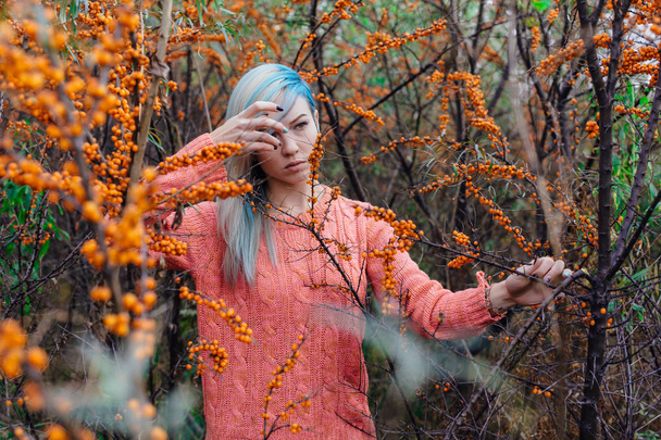 Portrait of a young woman in  bush  sea-buckthorn - Photo, image