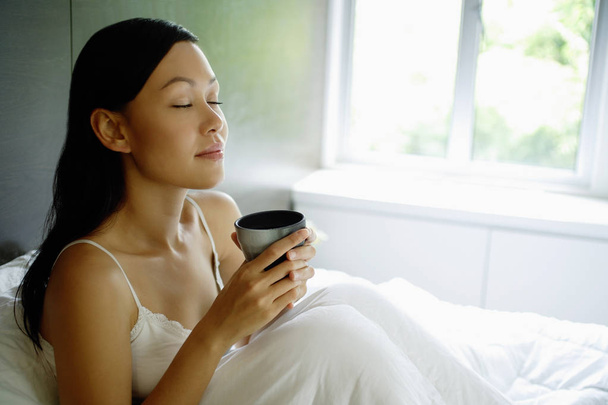 Frau im Bett mit Kaffeetasse - Foto, Bild