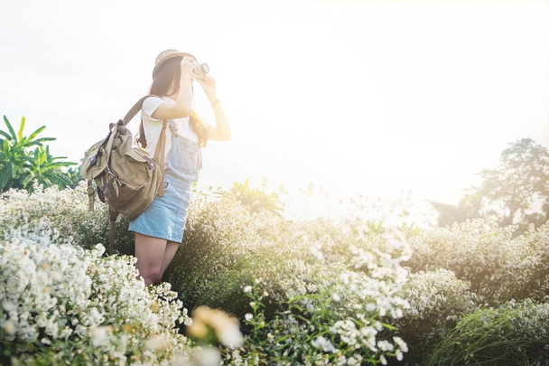 Χαριτωμένο κορίτσι έφηβος Ασίας hipster με τη φωτογραφική μηχανή σε λευκό λουλούδι στον κήπο, - Φωτογραφία, εικόνα