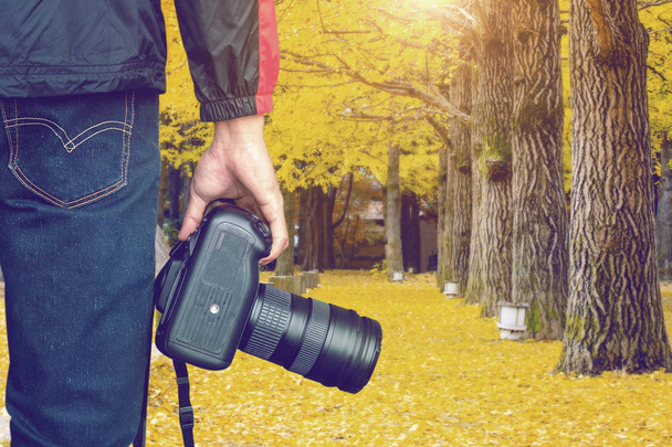 professional photographer with camera in autumn. Vintage tone. - Zdjęcie, obraz