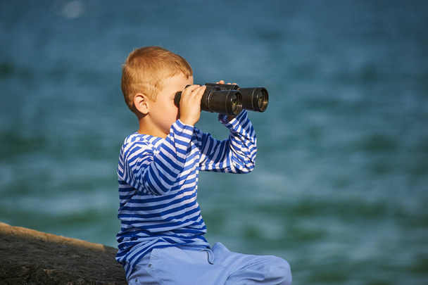 menino com binóculos, o mar no fundo
 - Foto, Imagem