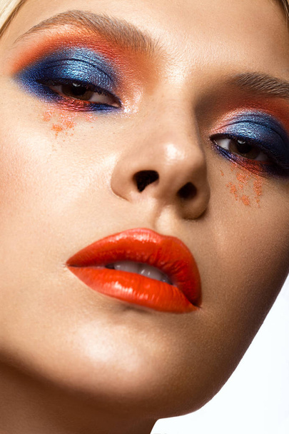Beautiful girl with bright colored makeup and orange lips. Beauty face. - Zdjęcie, obraz