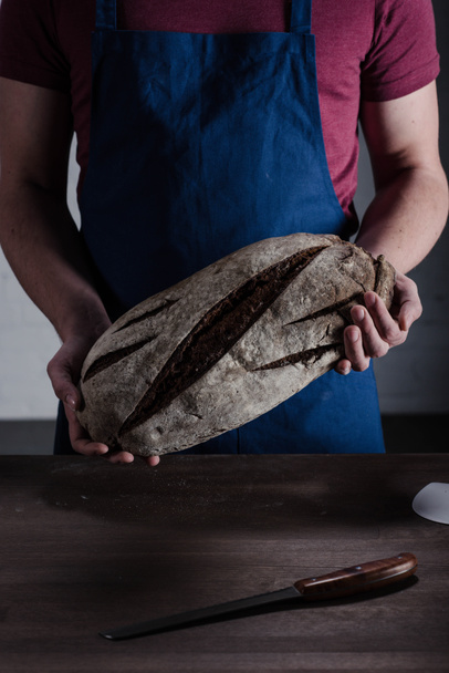 Baker holding bread - Фото, зображення