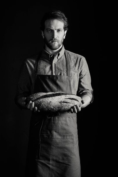 Panadero sosteniendo pan
 - Foto, Imagen