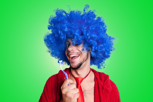 τρελός τύπος με μια οδοντόβουρτσα, περούκα και μπουρνούζι τραγούδι - Φωτογραφία, εικόνα