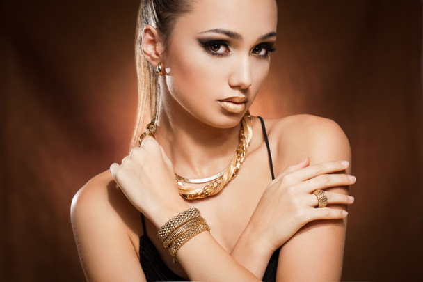 Woman wearing gold jewelry. - Фото, зображення