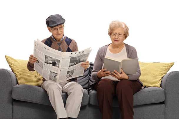 Seniors reading a newspaper and a book - Фото, изображение