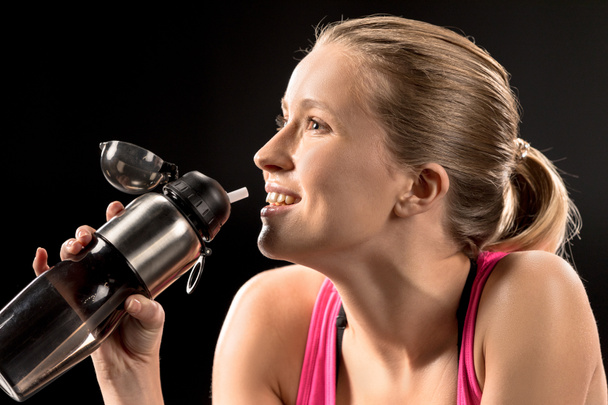 Sportswoman drinking water - Фото, изображение