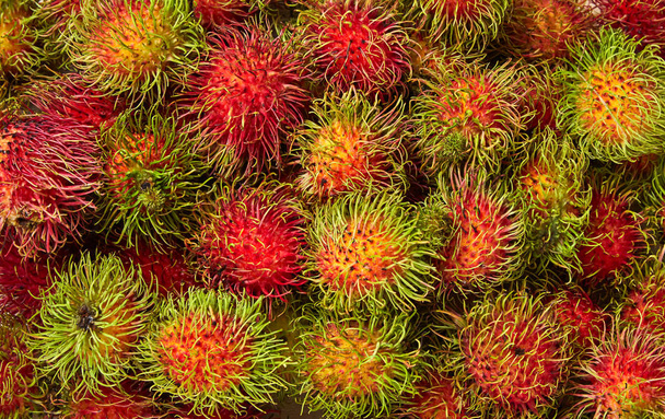Tuore rambutaani, aasialaiset hedelmät puupohjalla
 - Valokuva, kuva