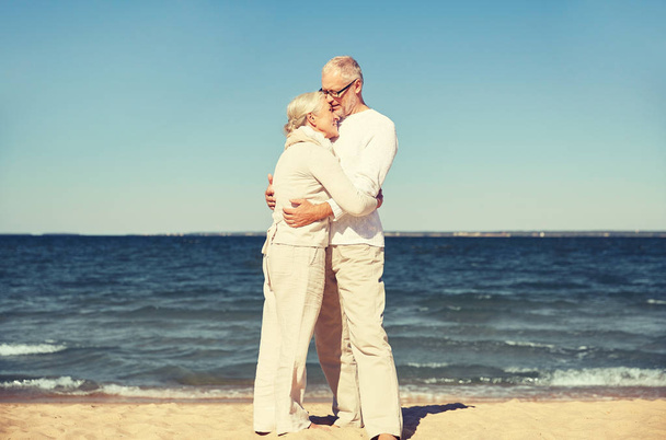 gelukkige senior paar knuffelen op zomer strand - Foto, afbeelding