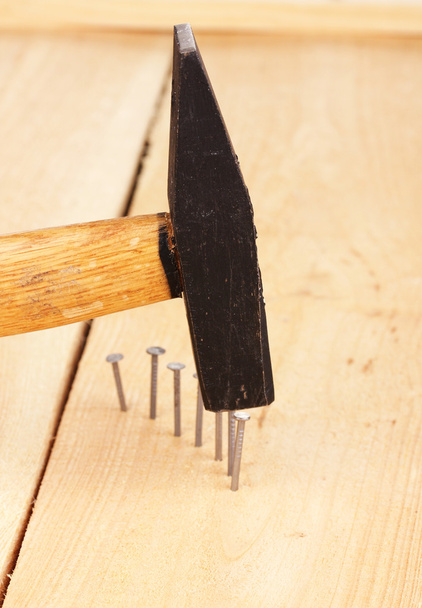 metalen nagels in houten plank en hammer - Foto, afbeelding
