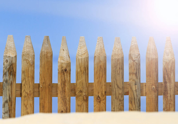 日当たりの良いホット スポットと砂に埋もれている木製フェンス - 写真・画像
