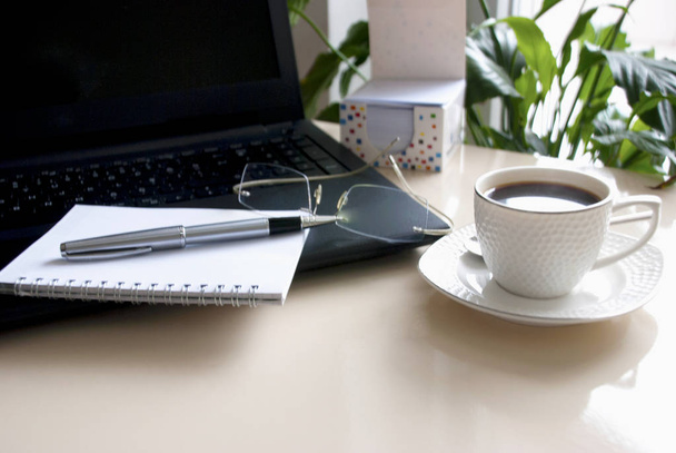 laptop ve kahve fincan üzerinde boş bir not defteri.  - Fotoğraf, Görsel