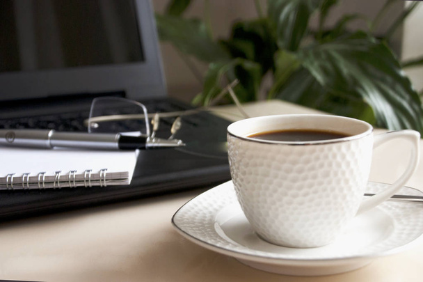 Blocco note vuoto su laptop e tazza di caffè
.  - Foto, immagini
