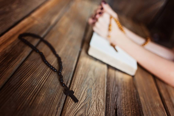 Womans hands with wooden rosary and Holy Bible - Foto, afbeelding