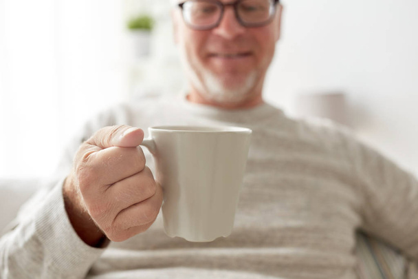 happy senior man with cup of tea or coffee at home - Φωτογραφία, εικόνα