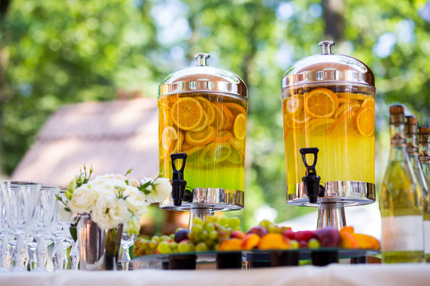 fruity lemonade, fruit refreshing drink, orange juice, catering, glasses for wine or champagne,exit buffet, Lemonade in glass barrels - Photo, Image