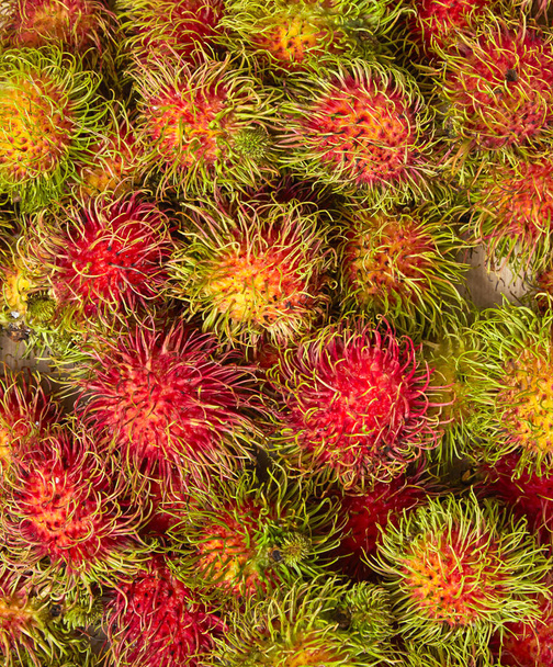 Tuore rambutaani, aasialaiset hedelmät puupohjalla
 - Valokuva, kuva