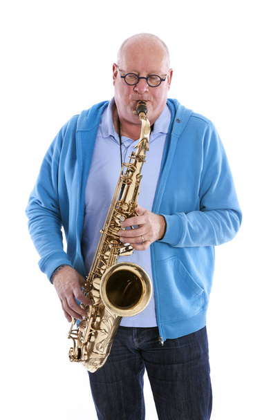 middle aged man plays the tenor saxophone against white studio b - Photo, Image