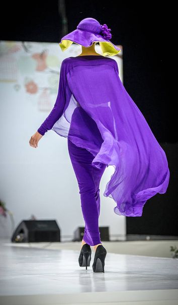 Beautiful young blonde woman in purple dress covered oriental veil - Foto, imagen