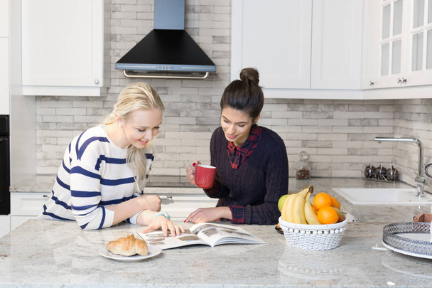 Two girls preparing breakfast in kitchen - Foto, afbeelding