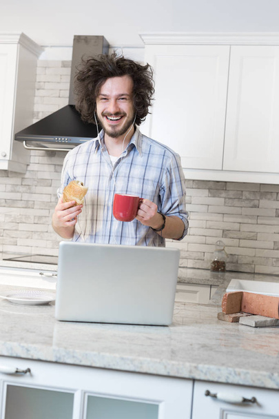 Man Eating Breakfast during Using Laptop - 写真・画像