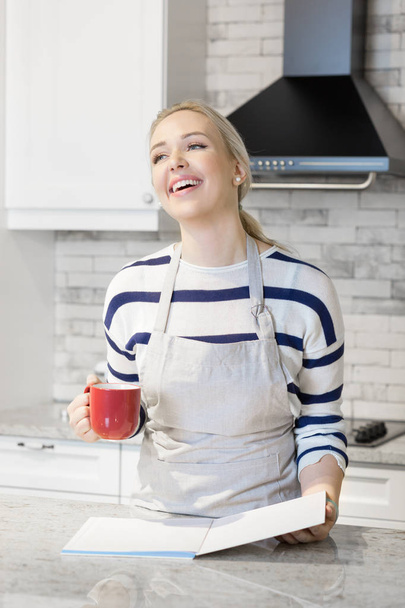 Woman drinking coffee in her kitchen - Photo, Image