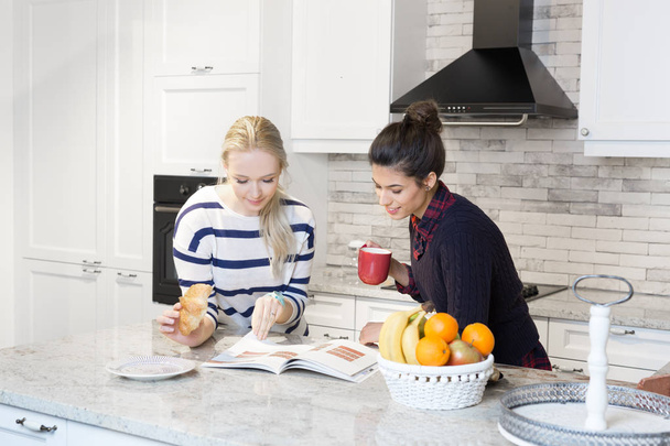 Two girls preparing breakfast in kitchen - Φωτογραφία, εικόνα
