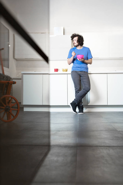 Man eating cereal in kitchen - Photo, image