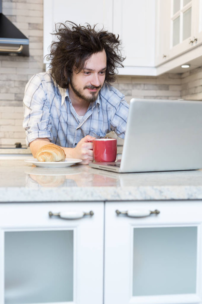 Man Eating Breakfast during Using Laptop - Foto, immagini